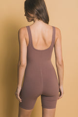 woman wearing a brown ribbed bodysuit with a scoop back and fitted shorts style