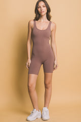 woman wearing a mauve ribbed bodysuit with a scoop neck and fitted shorts, styled with white sneakers