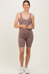 woman wearing a mauve ribbed maternity romper with a visible baby bump and white sneakers