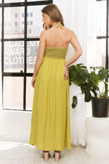 woman wearing a back view of a long olive green strapless maxi dress with a smocked bodice and a flowy skirt