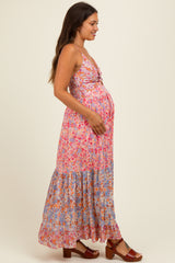 woman wearing a pink floral maternity maxi dress with a gathered bodice and a baby bump visible
