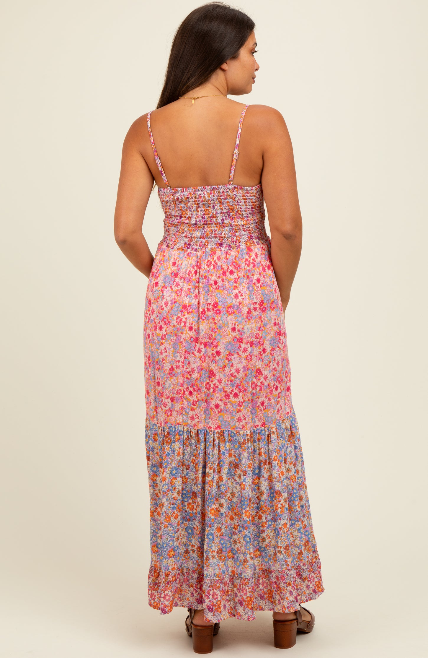 woman wearing a floral maternity maxi dress with a smocked bodice and tiered skirt, showing her baby bump from the back