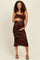 woman wearing a black floral print maternity dress and holding her baby bump