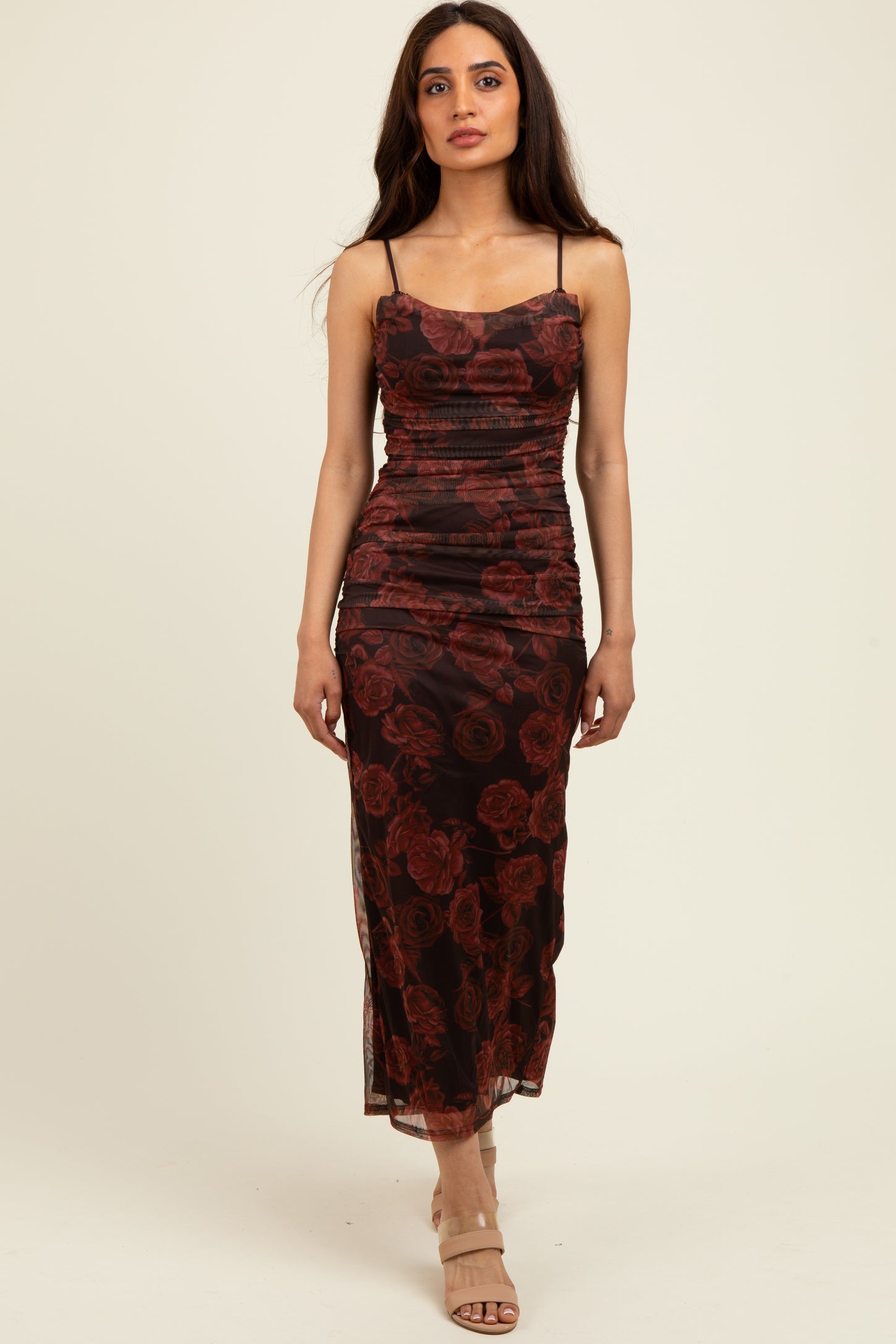 woman wearing a black floral midi dress with ruched detailing and thin straps