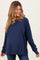 woman wearing a navy blue long sleeve maternity top with a loose fit and a visible baby bump