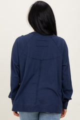 woman wearing a navy blue long sleeve top with a relaxed fit and unique seam detailing on the back