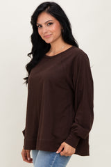 woman wearing a dark brown long sleeve oversized top with a relaxed fit and round neckline