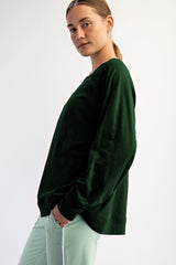 woman wearing a dark green long sleeve sweatshirt paired with light green pants