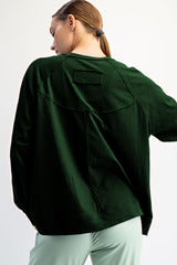 woman wearing a dark green oversized sweater with back seams and a relaxed fit