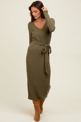 woman wearing an olive green ribbed long sleeve maxi dress with a tie belt and knee-high brown boots