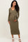 woman wearing an olive green ribbed maternity dress with a tie waist and showing her baby bump