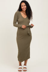 woman wearing an olive green ribbed maternity dress with a v-neck and tie waist, showing her baby bump