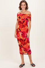 woman wearing a colorful off-the-shoulder midi dress with a floral pattern and a fitted silhouette