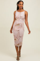 woman wearing a pink floral midi dress with one strap and a fitted silhouette, posing confidently