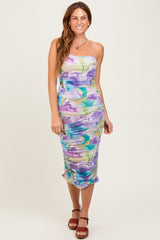woman wearing a colorful floral print midi dress with adjustable spaghetti straps and ruched detailing