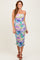 woman wearing a colorful floral print midi dress with adjustable spaghetti straps and ruched detailing