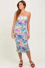 woman wearing a colorful floral midi dress with adjustable spaghetti straps and gathered fabric details