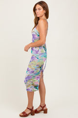 woman wearing a colorful floral print midi dress with side ruching and a fitted silhouette