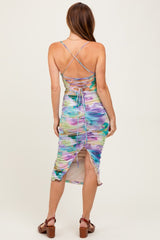 woman wearing a multicolored fitted dress with a ruched design and crisscross back details