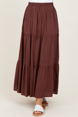 woman wearing a burgundy tiered maxi skirt with an elastic waistband and paired with white slide sandals