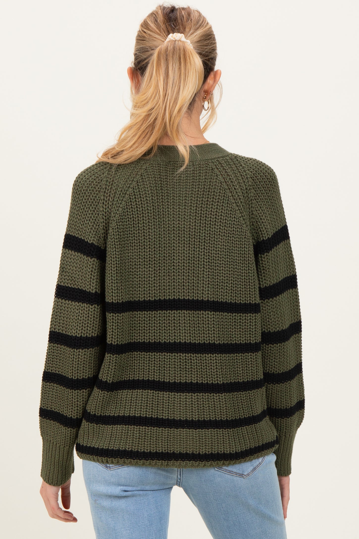 woman wearing an olive green striped maternity sweater, showing the back view with a relaxed fit and soft texture