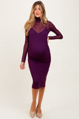 woman wearing a purple maternity dress with a sheer long sleeve overlay and a fitted silhouette, showcasing her baby bump