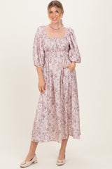 woman wearing a pink floral midi dress with puff sleeves and side pockets