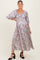 woman wearing a purple floral maxi maternity dress with puff sleeves and a visible baby bump