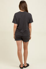 woman wearing a black and white striped maternity loungewear set with a short sleeve top and shorts, showing her back