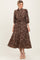 woman wearing a brown floral midi dress with puffed sleeves and tie waist detail