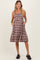 woman wearing a brown and white plaid maternity dress with pockets and a tiered skirt