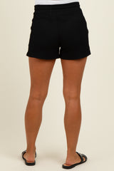 woman wearing black maternity shorts, showcasing a comfortable elastic waistband and casual style from the back