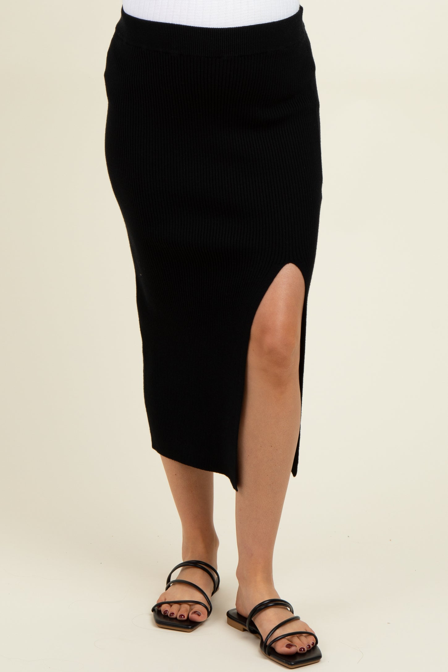woman wearing a black ribbed maternity midi skirt with a side slit and sandals