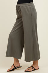 maternity wear in olive green wide leg pants with adjustable drawstring waist, model standing sideways