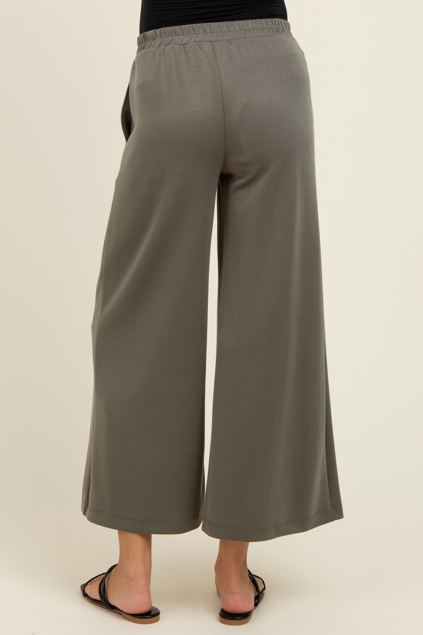 woman wearing a pair of gray wide-leg maternity pants with an elastic waistband, viewed from the back