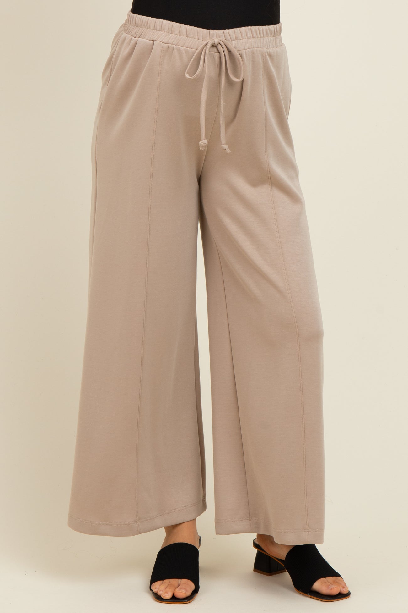 woman wearing light gray wide-leg maternity pants with an elastic waistband and drawstring detail