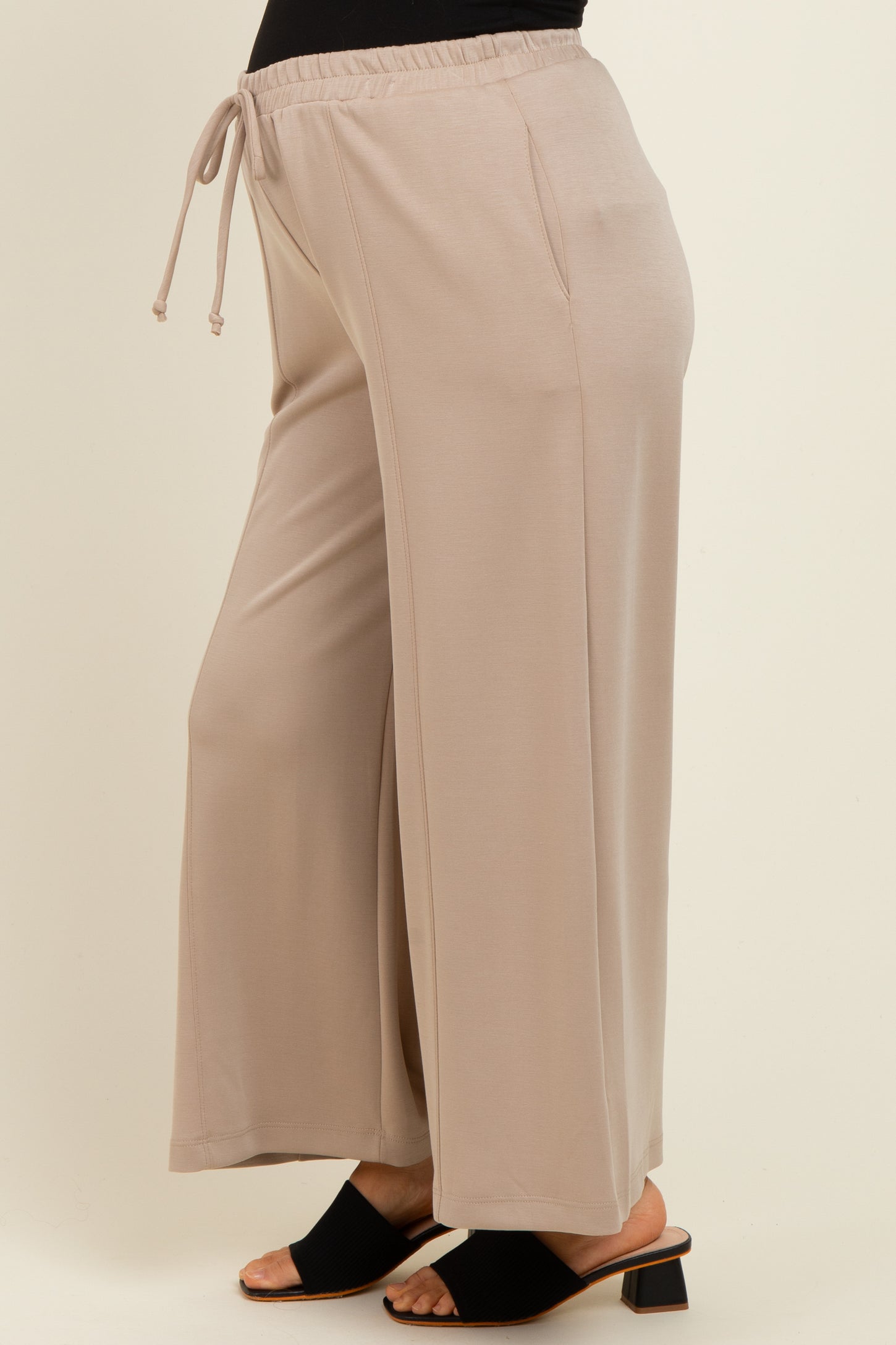woman wearing beige maternity wide-leg pants with an elastic waistband and drawstring
