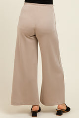 woman wearing beige maternity wide-leg pants with an elastic waistband, viewed from the back