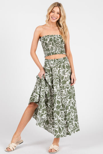 woman wearing a green and white floral two-piece set with a strapless crop top and a flowy maxi skirt
