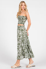 woman wearing a green and white floral two-piece set with a smocked crop top and long skirt