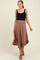 woman wearing a black tank top and a dusty rose maternity skirt, walking gracefully with a relaxed fit