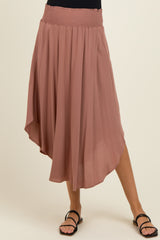 woman wearing a dusty rose maternity skirt with a smocked waistband and asymmetrical hemline
