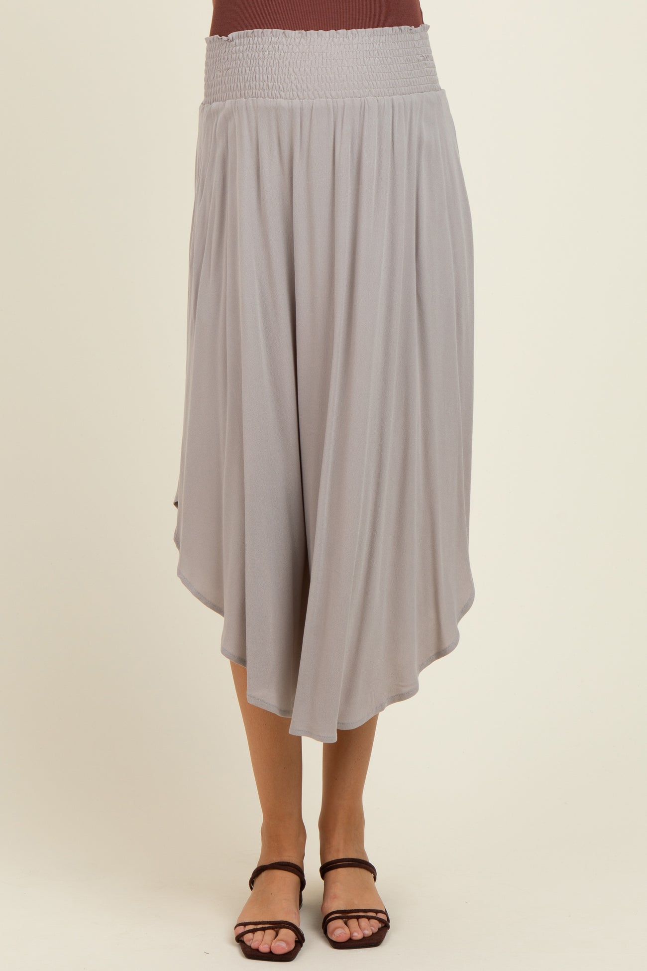 woman wearing a light gray maternity skirt with a smocked waistband and an asymmetrical hemline