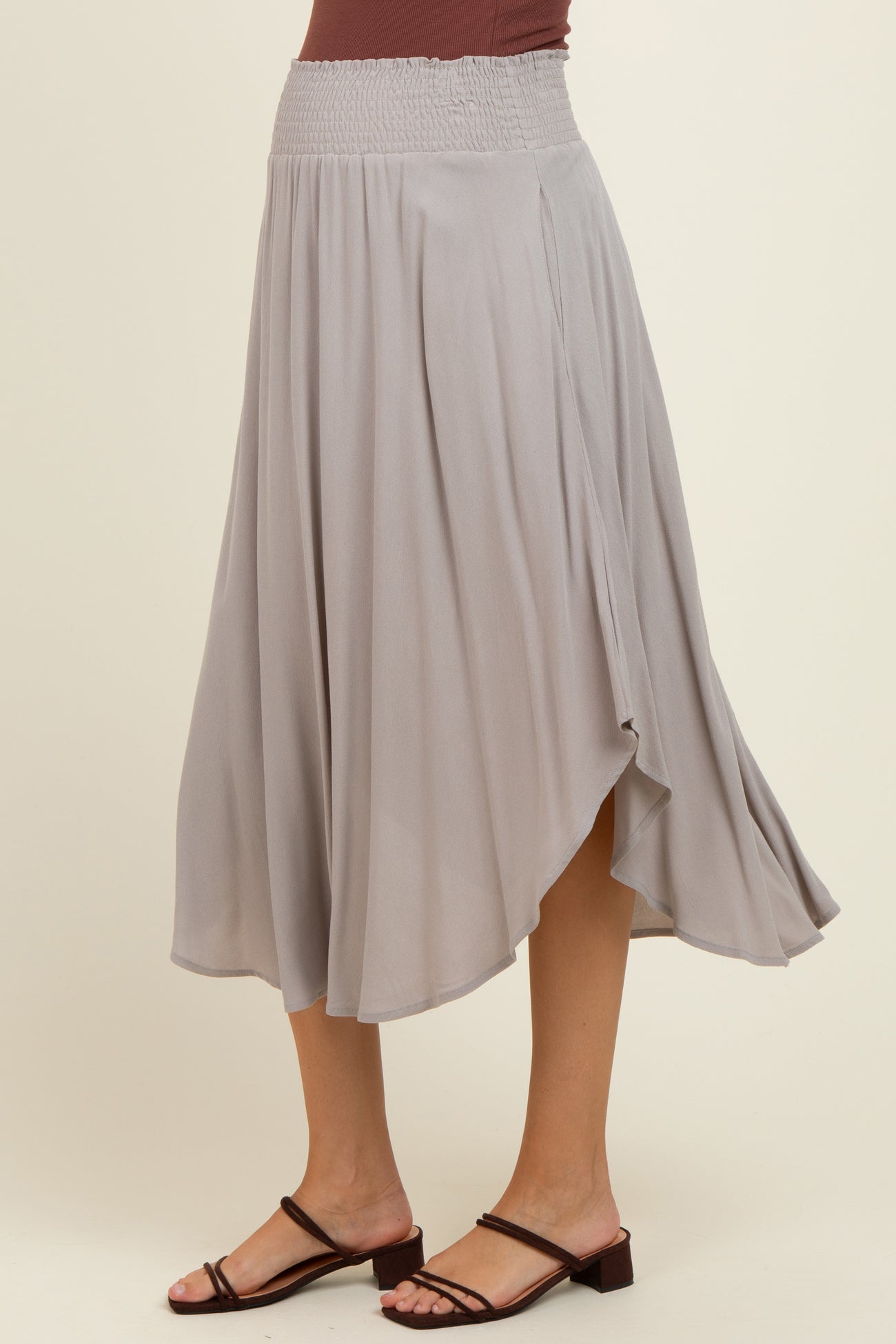 woman wearing a grey maternity wrap skirt with a smocked waistband and flowing hemline