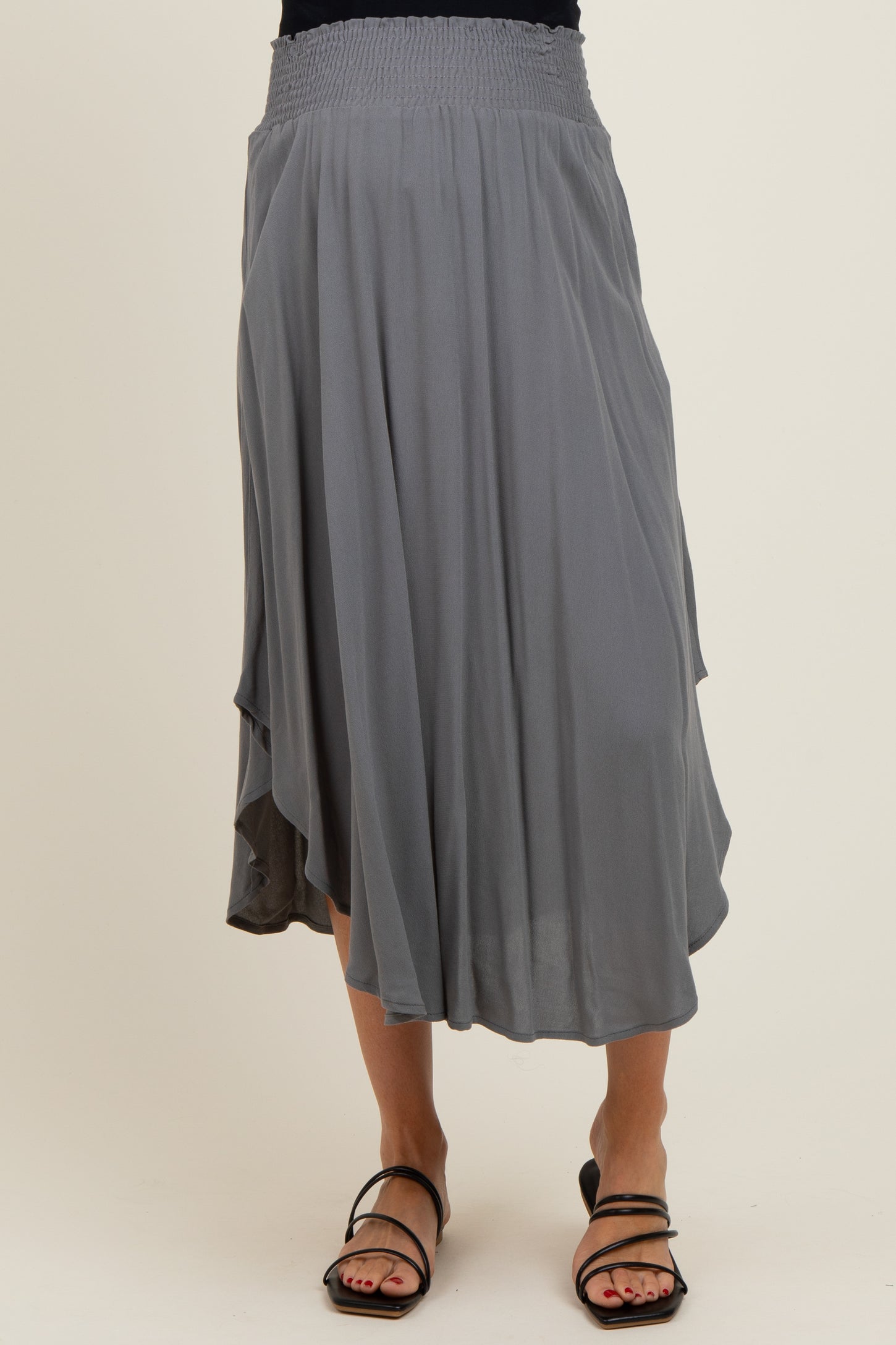woman wearing a gray maternity skirt with a smocked waistband and flowy silhouette