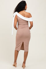 woman wearing a fitted beige maternity dress with an off-shoulder white tie detail and a back slit