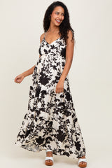 woman wearing a black and white floral maternity maxi dress with adjustable straps and a baby bump visible