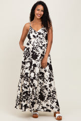 woman wearing a black and white floral maternity maxi dress with a baby bump and pockets