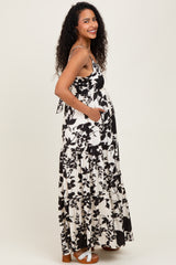 woman wearing a black and white floral maternity maxi dress with a baby bump and pockets