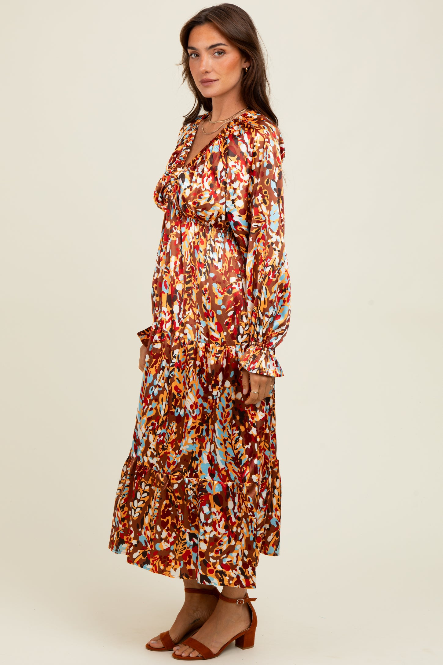 woman wearing a multicolored long sleeve maxi dress with a tiered skirt and ruffled details
